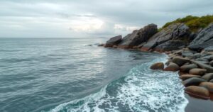 Serene coastal scene of Santiago de Cuba with gentle waves and cloudy sky reflecting calming colors.