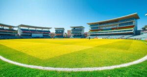 Colorful cricket field at Harare Sports Club with empty stadium under a clear blue sky, ready for international matches.