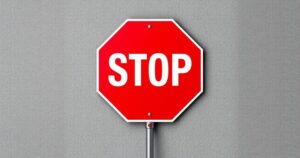 A bold red stop sign with a textured background, symbolizing travel restrictions and barriers.