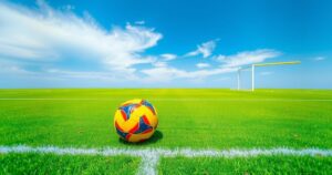 Soccer field with a vibrant green background and colorful soccer ball representing teamwork and sportsmanship.