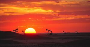 Dramatic landscape of a Libyan oil field under sunset, showcasing industry and nature in harmony.